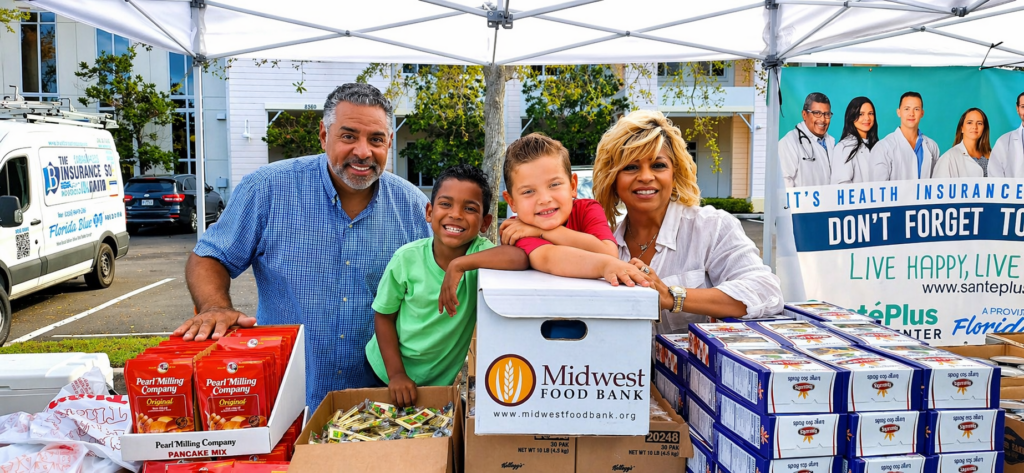 family smiling with Midwest Food Bank food boxes